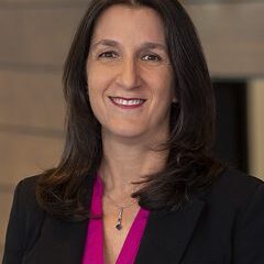 Smiling woman in professional attire indoors.